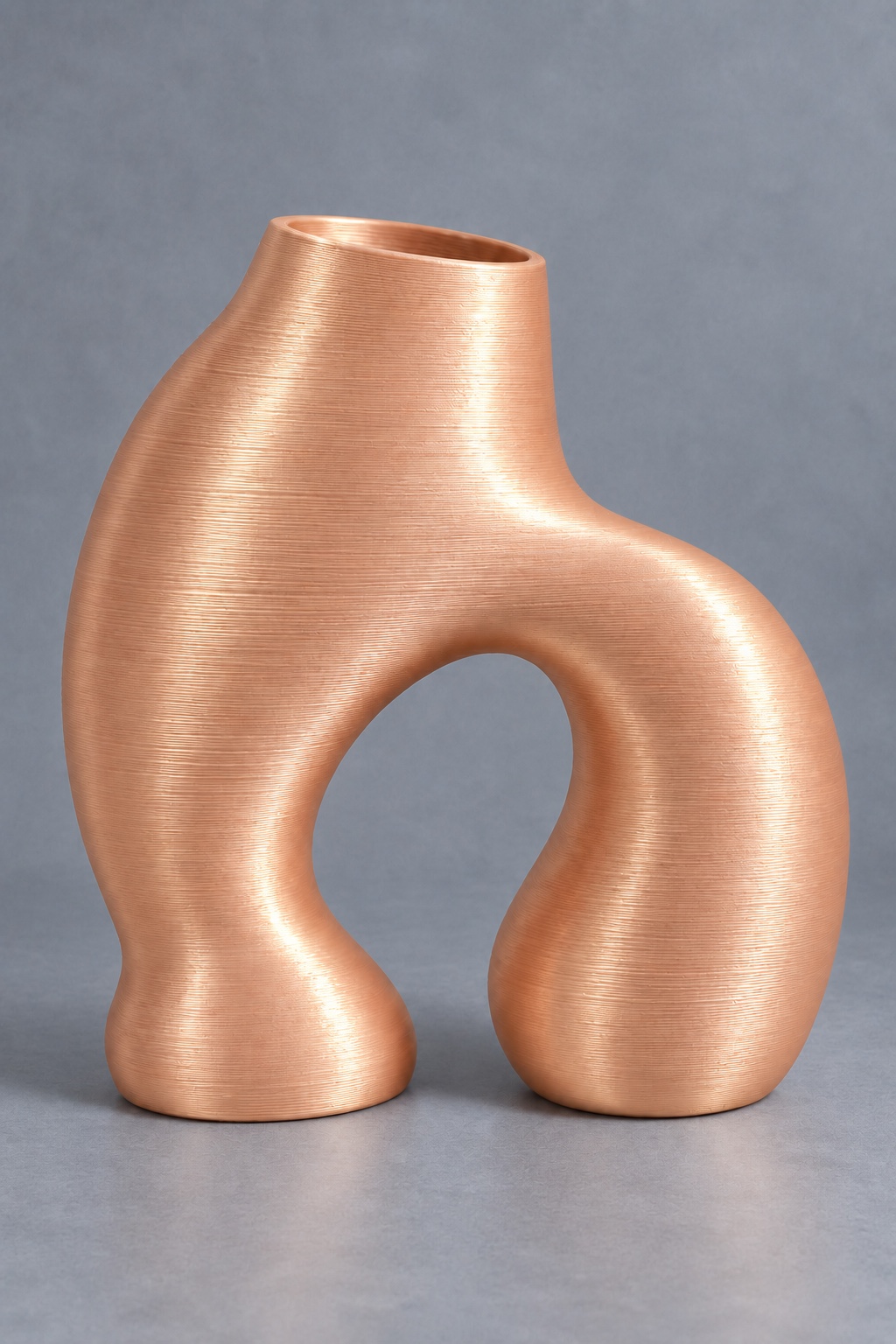Pebble Portal vase concept with two asymmetric fused pebble forms with a lower arch opening, front view, in the Pomelo Orange color direction. AI visualization.