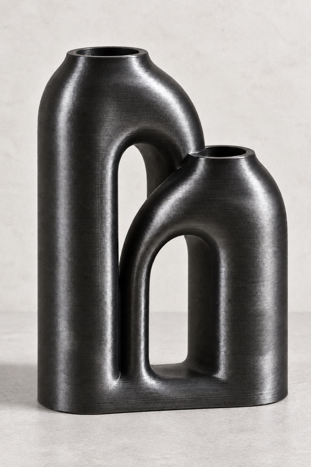 Arc Duo vase concept with two interwoven domed arches with two flower openings, front view, in the Silk Midnight Black color direction. AI visualization.